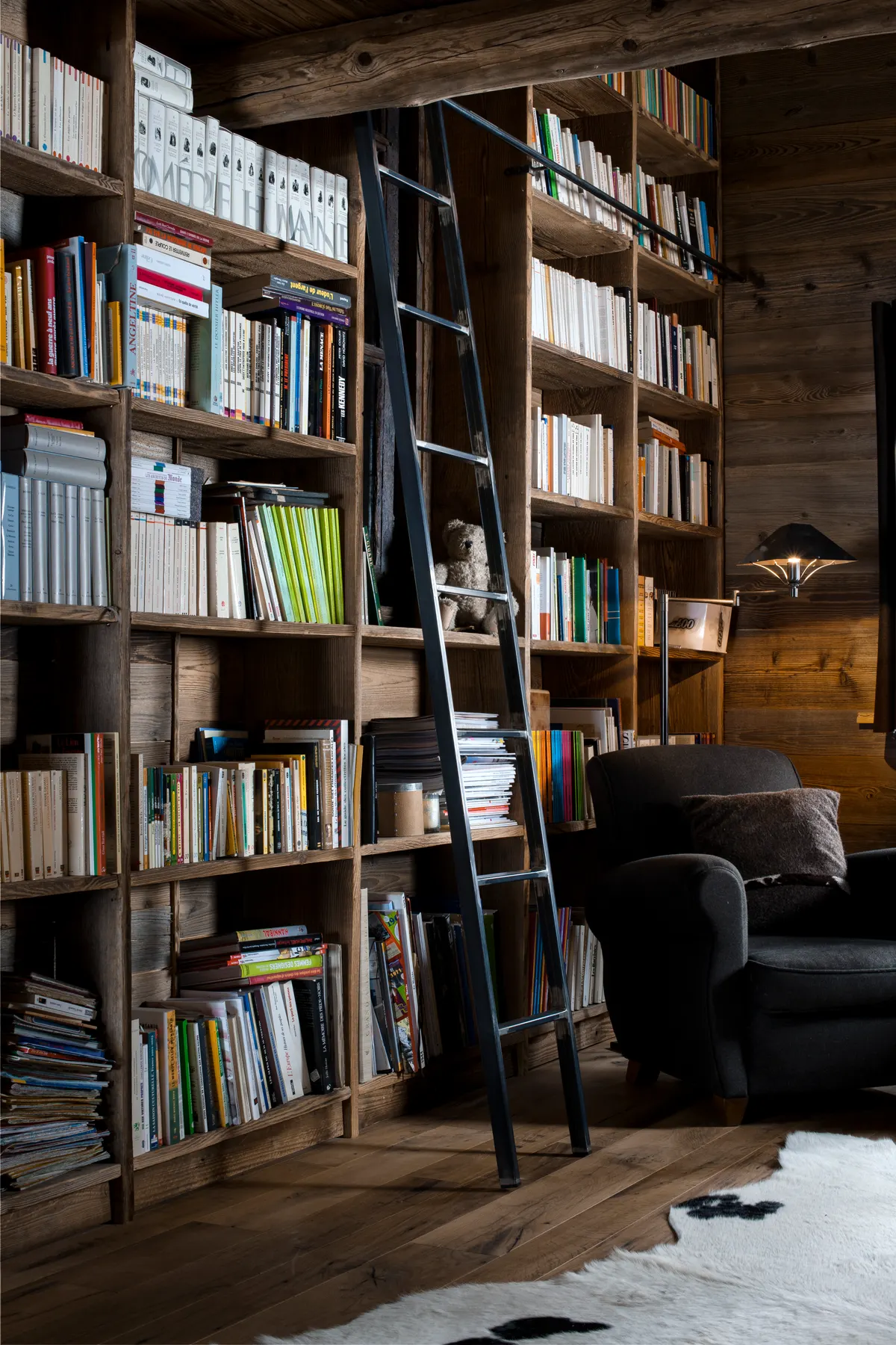 Rayonnages de livres, échelle et fauteuil en cuir