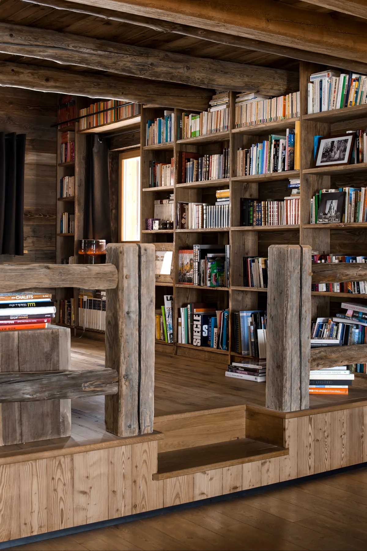 Bibliothèque en vieux bois sur toute la hauteur, rambarde en madriers
