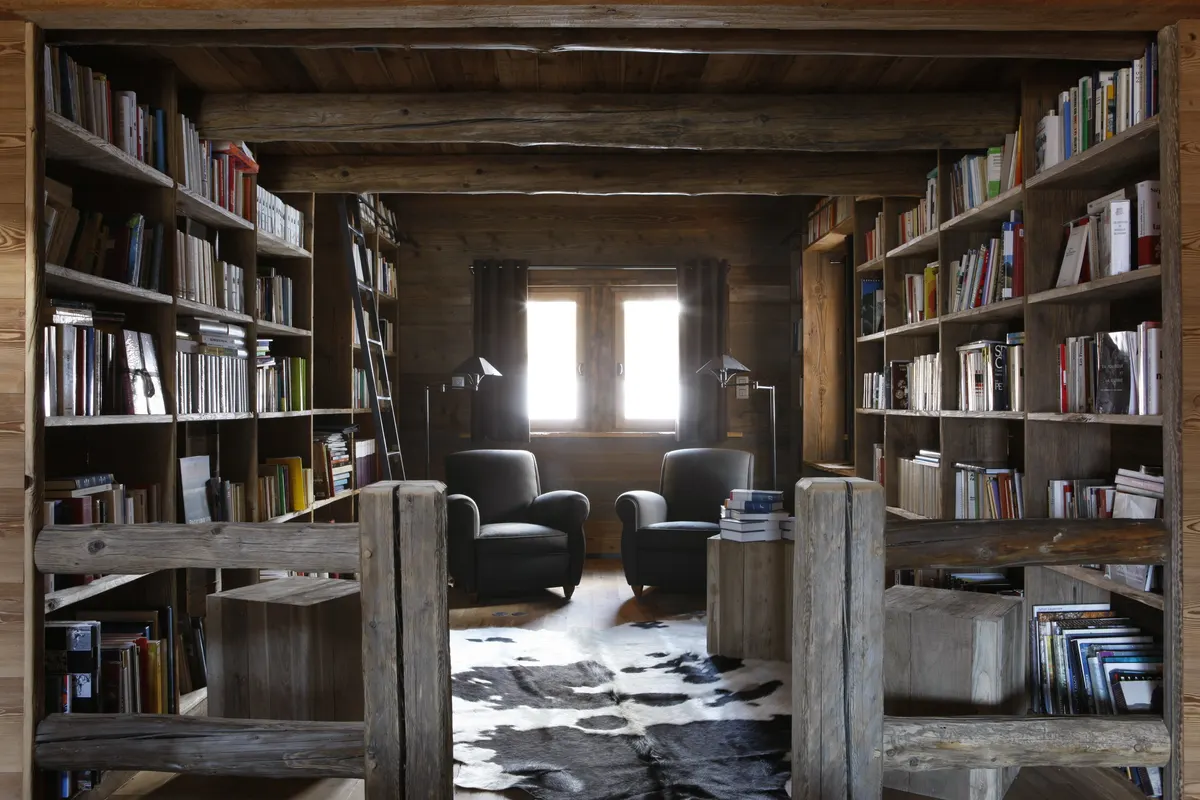 Coin lecture entre deux bibliothèques face à une fenêtre
