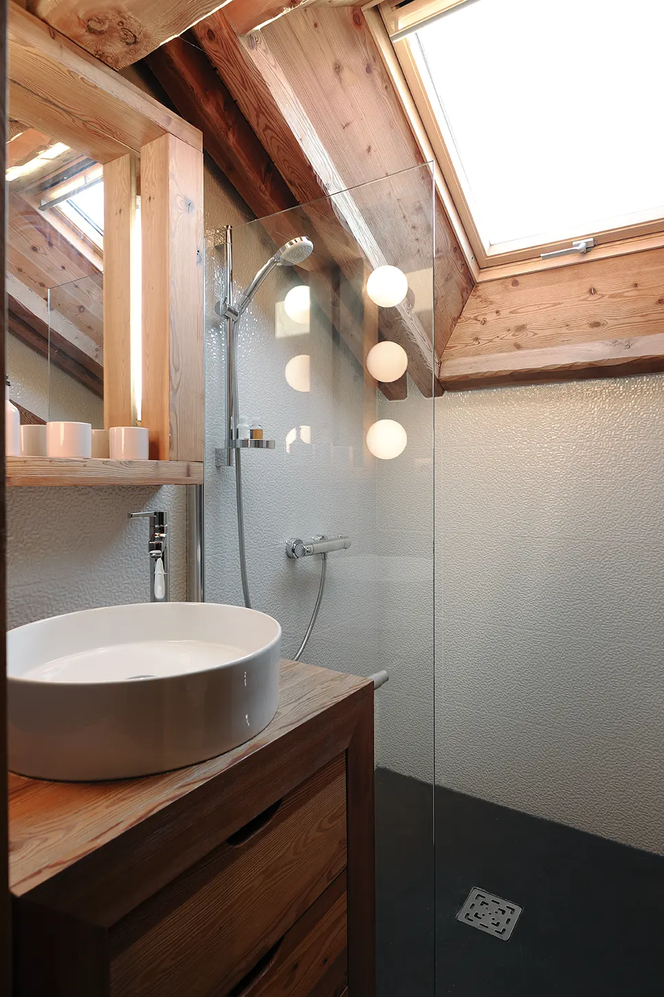 Salle de bain sous le velux, vasque ronde et douche vitrée