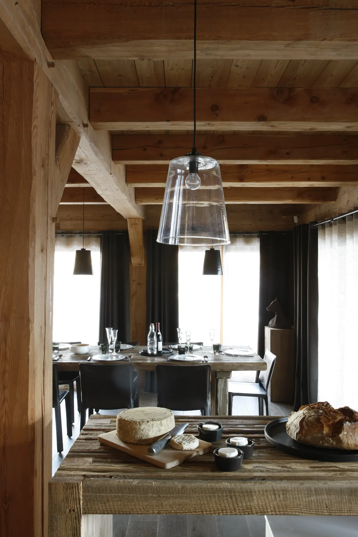 Table de la salle à manger dressée, suspension en verre, poutres apparentes
