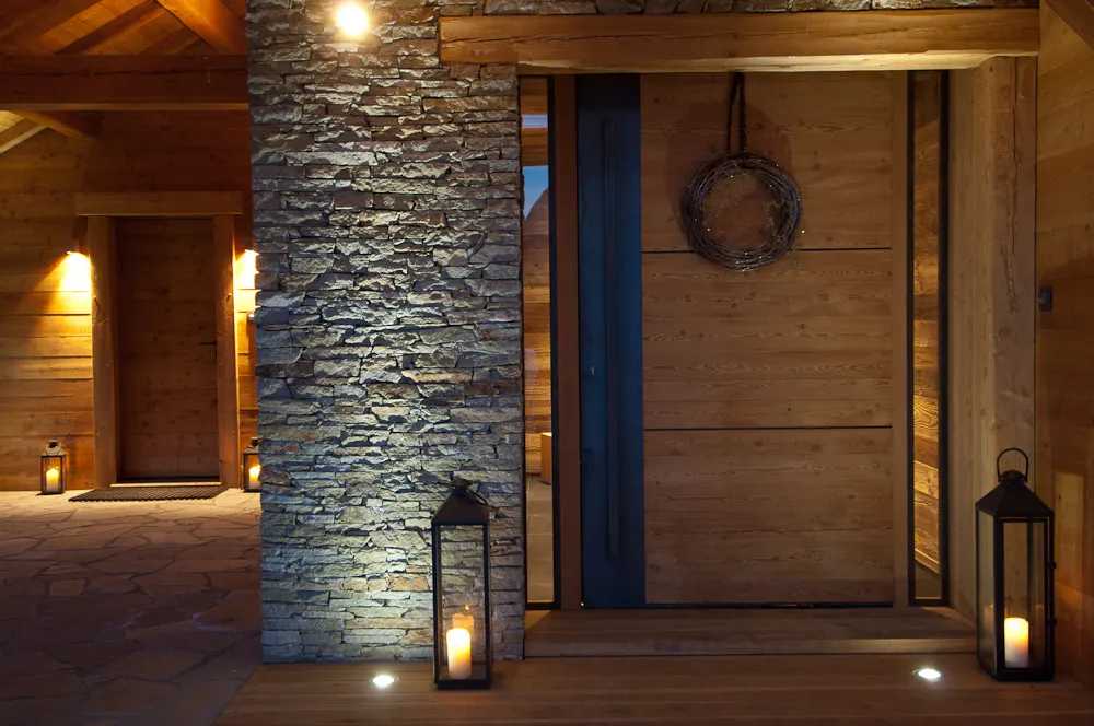 Entrée du chalet, pilier de pierre et lanternes au sol