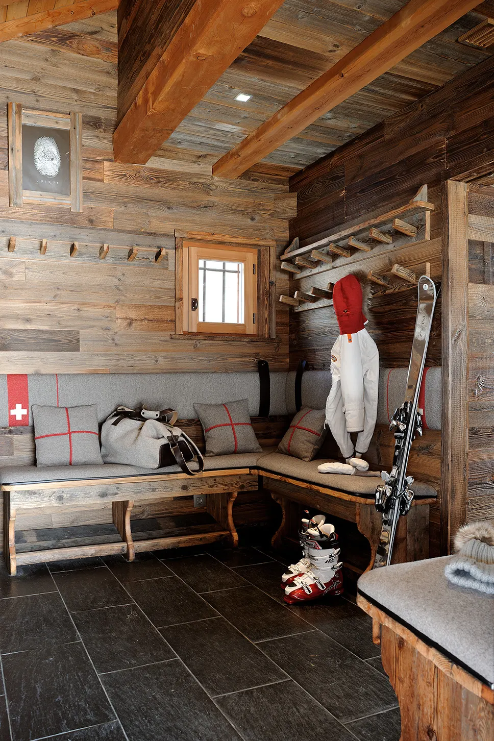 Local à skis en vieux bois et ardoise avec banquettes et patères