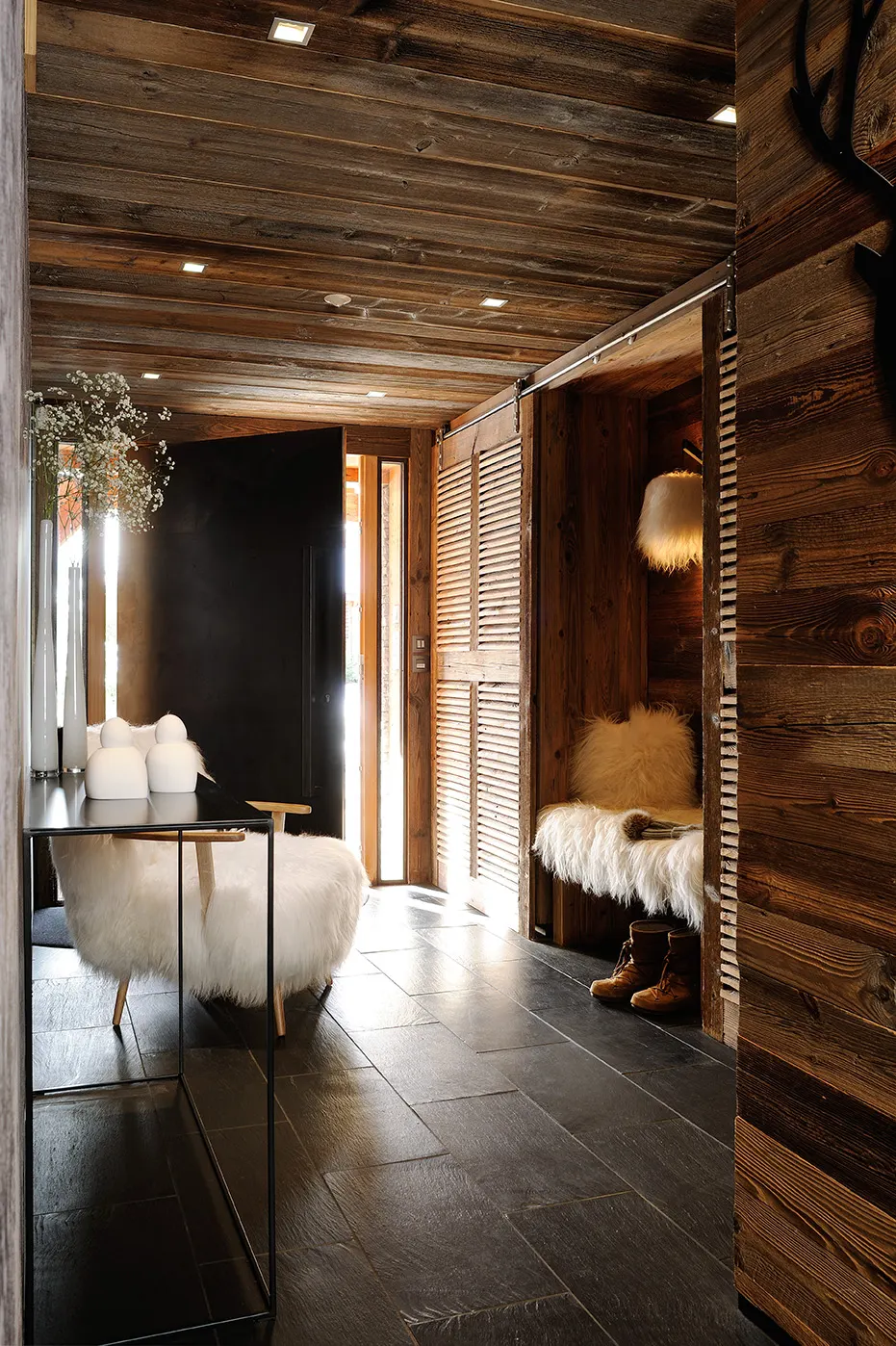Couloir en vieux bois, banquette en peau de mouton et bougies